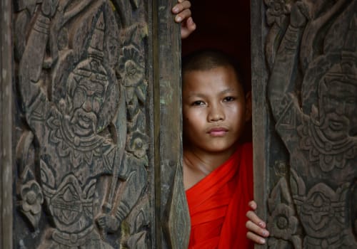 Monk novice looking out from the wooden carved door