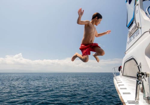 Kid jumping from the side of a boat
