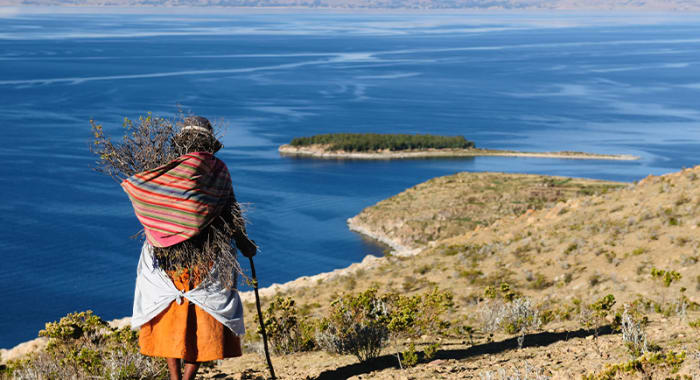 Old woman walking shore lake titicaca