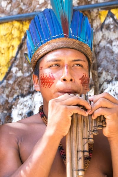 Native Brazilian Guys Playing Wooden Flute At An Indigenous Tribe