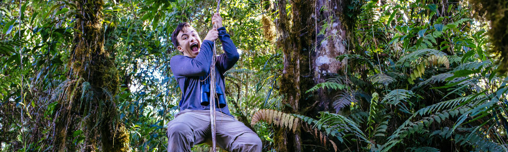 Teenage boy zip-lining in a jungle